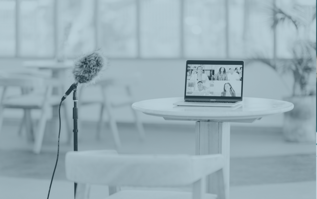 A. table with a small laptop on it and a mic standing next to it